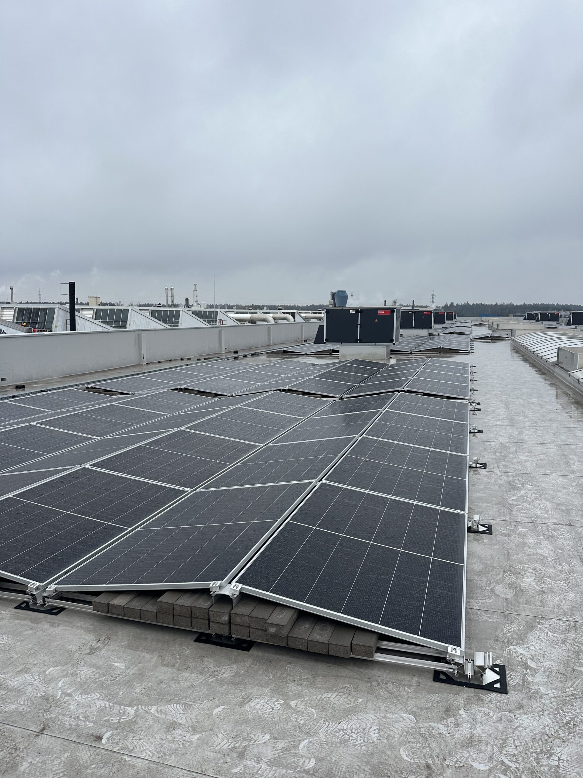 Ballasted flat roof solar installation on an industrial building with photovoltaic panels for renewable energy production.