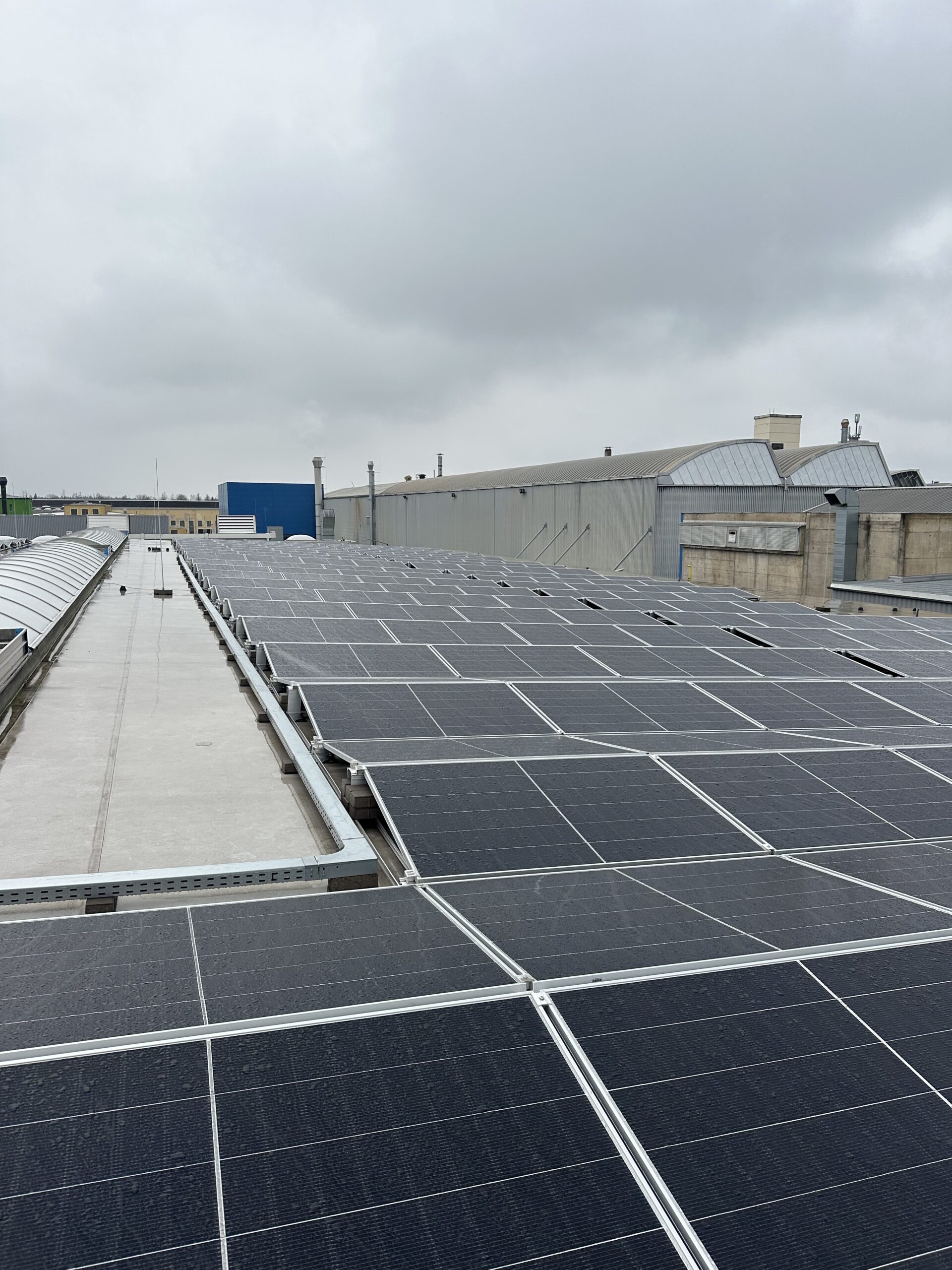 Commercial flat roof solar installation on an industrial building with high-efficiency photovoltaic panels.
